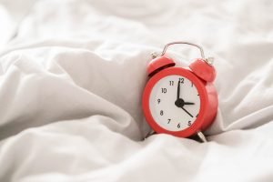 Red alarm clock in a bed